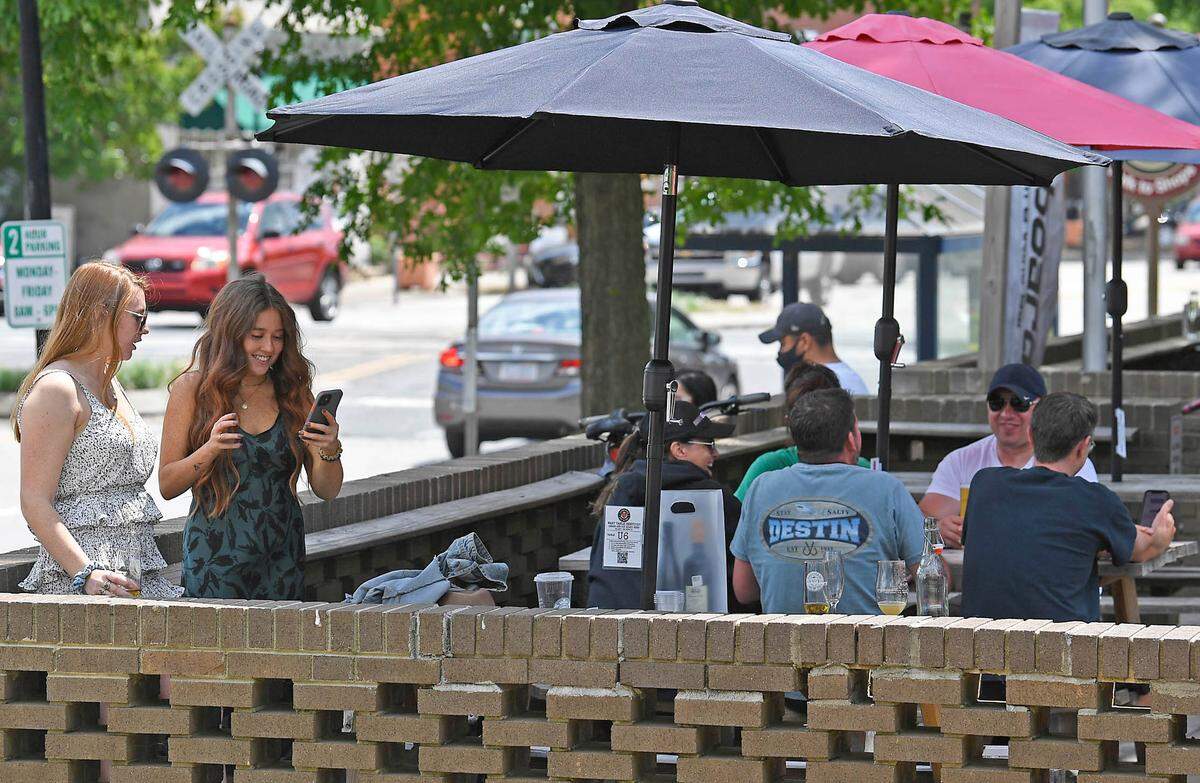 Customers enjoy themselves on the patio at Seaboard Brewing Taproom and Wine Bar in Matthews on Friday, May 14, 2021. North Carolina Gov. Roy Cooper on Friday lifted most mask mandates, effective immediately, signaling an accelerated path to pre-pandemic “normal.”