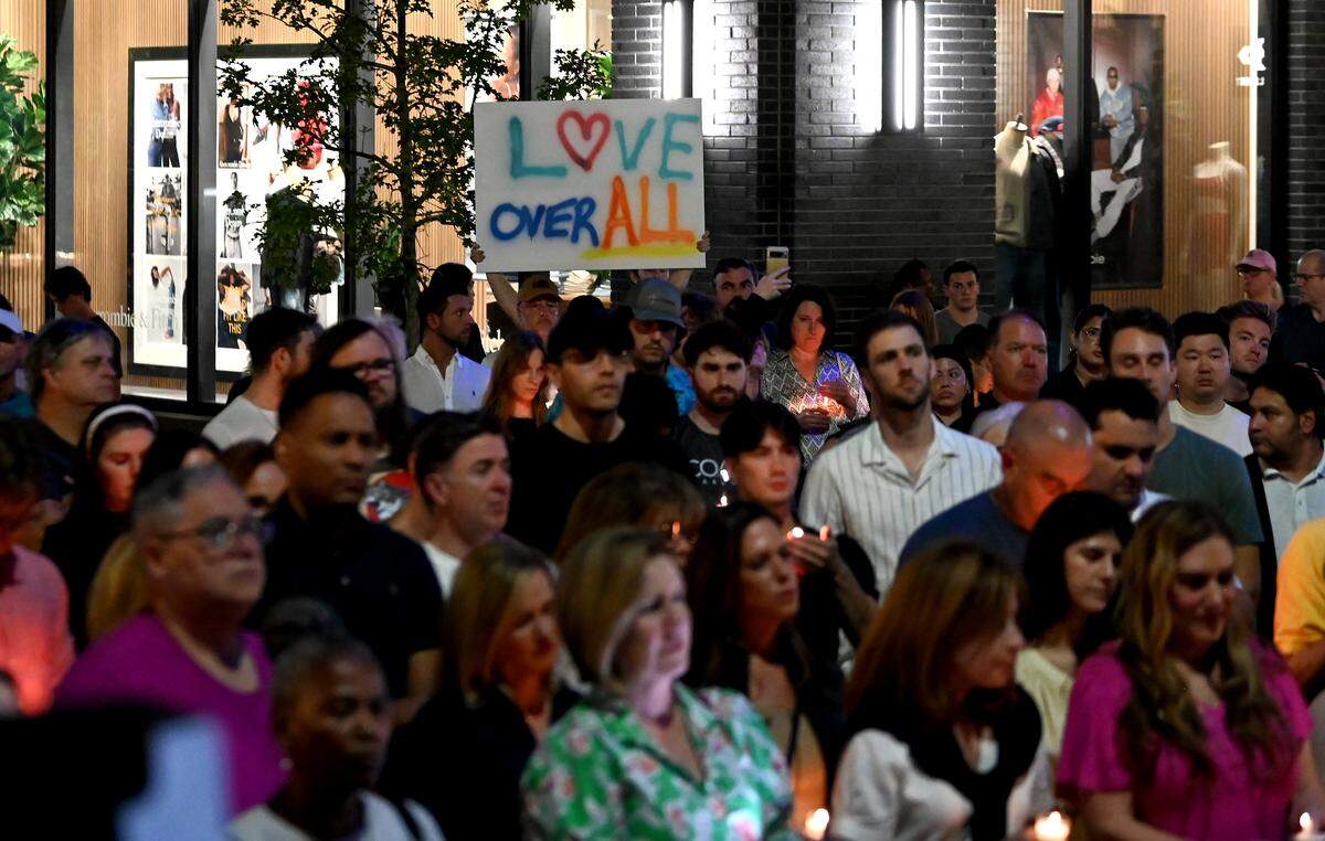 Douglas Kandora of Charlotte holds a sign above the crowd gathered for a memorial service for Iryna Zarutska on Monday in Charlotte. 