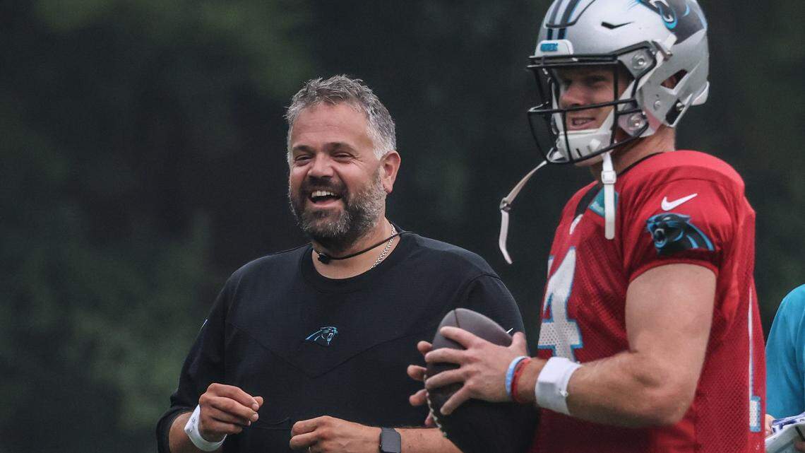 Carolina Panthers coach Matt Rhule, left, shares a laugh with Sam Darnold during a drill at training camp last summer. Rhule has final say on all Panthers roster decisions, including trading quarterbacks.