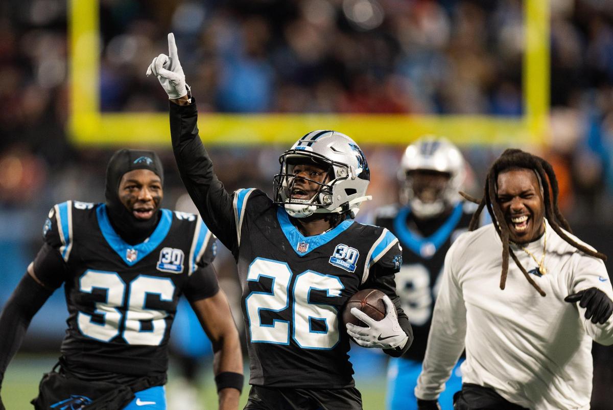 Carolina Panthers cornerback Chau Smith-Wade celebrates an interception with special teams assistant coach Daren Bates (far right) and teammates against the Tampa Bay Buccaneers at the Bank of America Stadium in Charlotte, N.C., on Sunday, December 1, 2024.