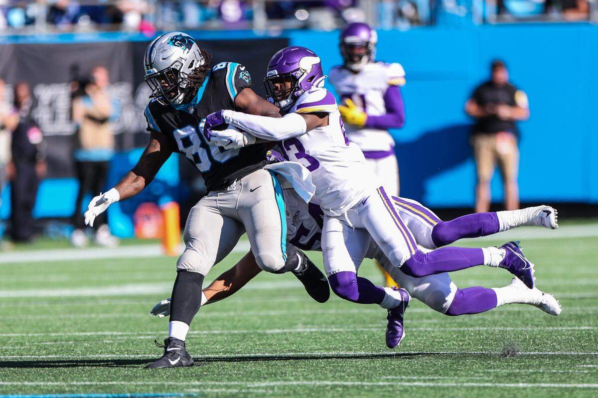 Panthers tight end Ian Thomas, left, runs the ball as he fights off Vikings safety Xavier Woods during the game at Bank of America Stadium on Sunday, October 17, 2021 in Charlotte, NC.