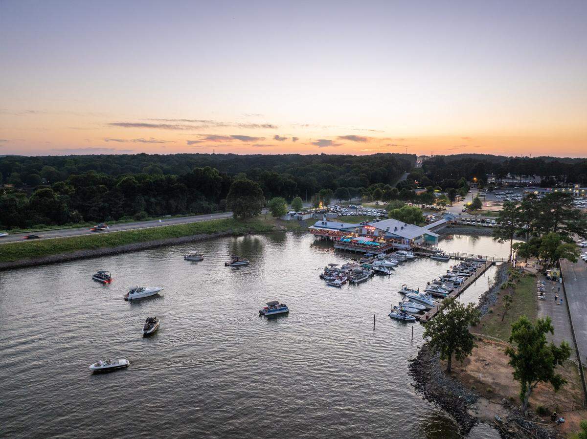The sun sets over Lake Wylie near the Buster Boyd Bridge. You can see Papa Doc’s Shore Club restaurant, which has a waterfront patio.