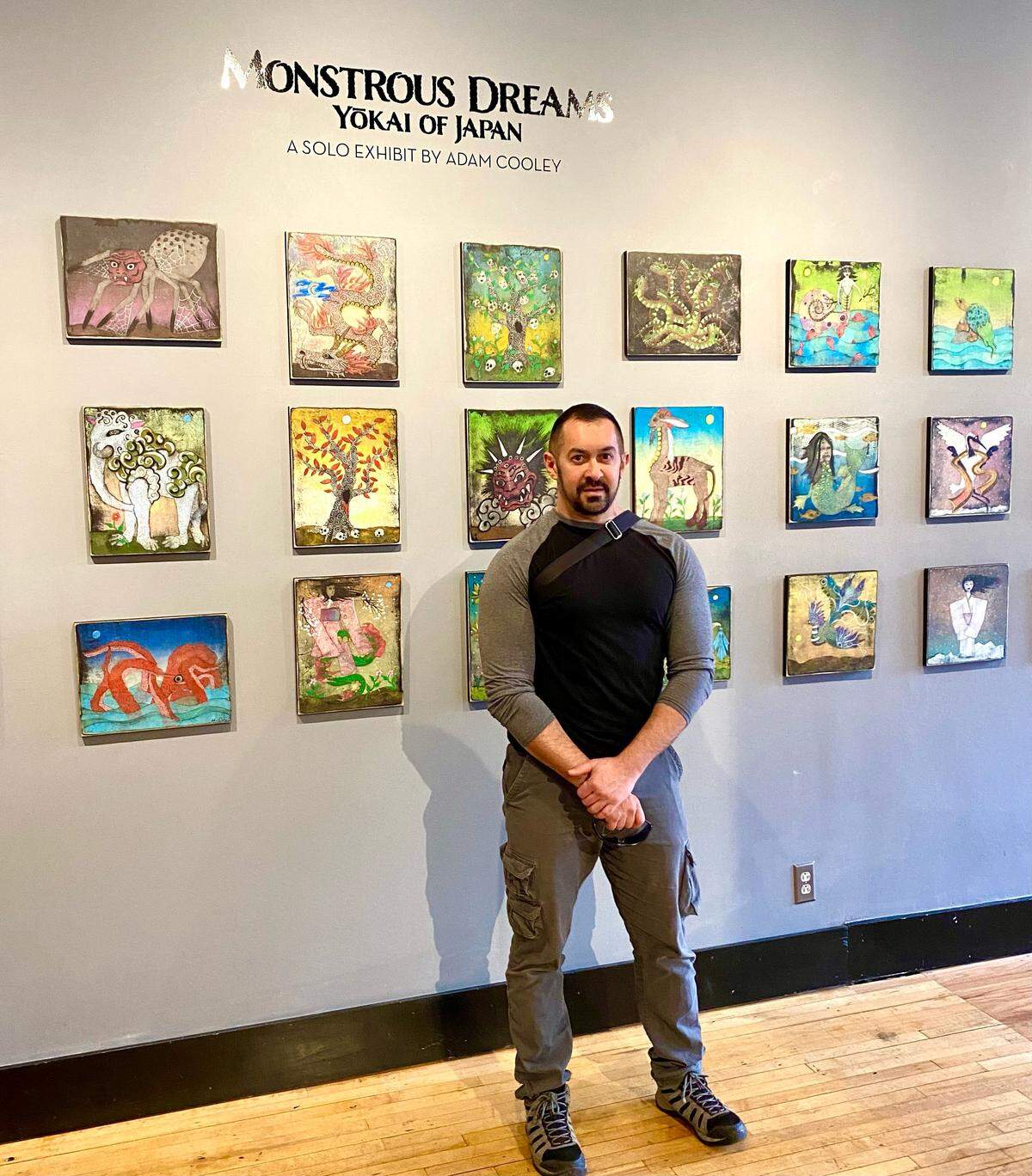 Adam Cooley of Durham, shown with his artwork on exhibit in Japan, has not been able to get his consigned artwork back after Galleries at 811 in Charlotte abruptly closed in September.