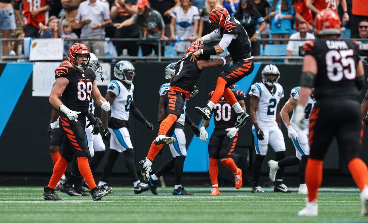 Bengals wide receiver Ja’Marr Chase, left center, and quarterback Joe Burrow jump in the air to celebrate a touchdown during their game against the Panthers on Sunday at Bank of America Stadium.