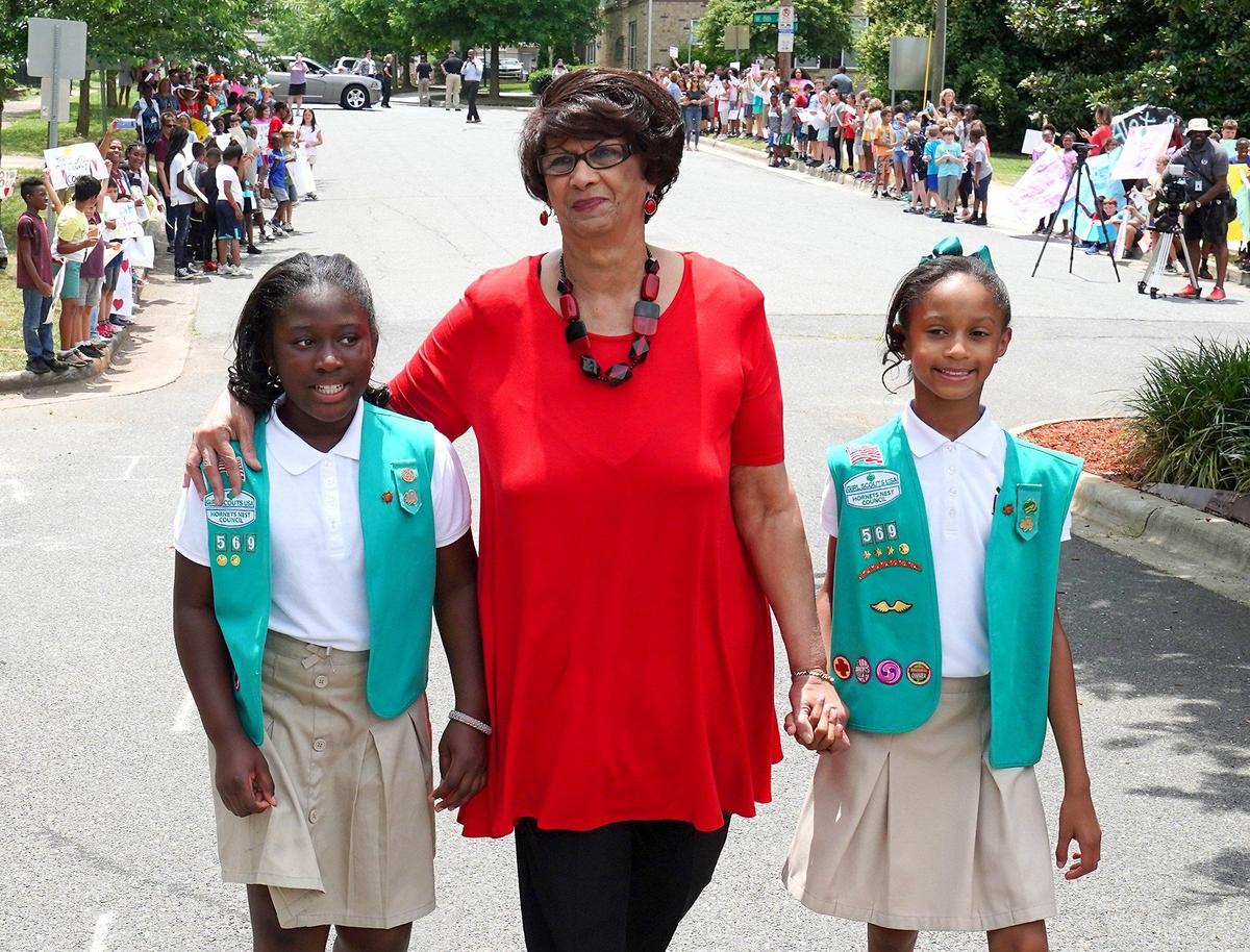 Dorothy Counts-Scoggins, center, is escorted to Irwin Academic Center by students and Girl Scout Troop 569 members Morgan Winston, left and Maya McClain, right in Charlotte, NC on Friday, May 31, 2019. On September 4, 1957, the scene was much different when Counts-Scoggins was one of four black students enrolled at various all-white schools in the Charlotte district. Irwin Academic Center was then Harding High School. Counts-Scoggins was harassed, taunted and spit on in 1957 but on Friday, May 31, 2019 she walked back down the hill to the school to chants of Dorothy....Dorothy...Dorothy. A bench was presented to Counts-Scoggins outside the school with a name plate honoring her role in the Civil Rights movement.