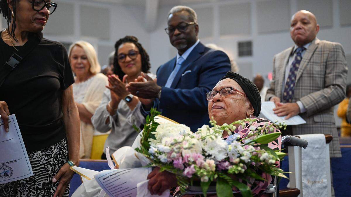 Ms. Lallage M. Caouthers, RN, BSN, center, receives flowers and a stading ovation during an unveiling ceremony at Ebenezer Baptist Church for an NC highway historical marker recognizing Good Samaritan Hospital in Charlotte on Thursday, May 28, 2026. Carouthers, who is 89 years old, was part of the Good Samartian nursing graduating class of 1957. Good Samartian Hospital was built to serve the medical needs of Black people in Charlotte. Additionally, it was the first privately funded hospital in North Carolina which served Black patients. The original building was destroyed in 1996 to make way for construction of what is now Bank of America Stadium.