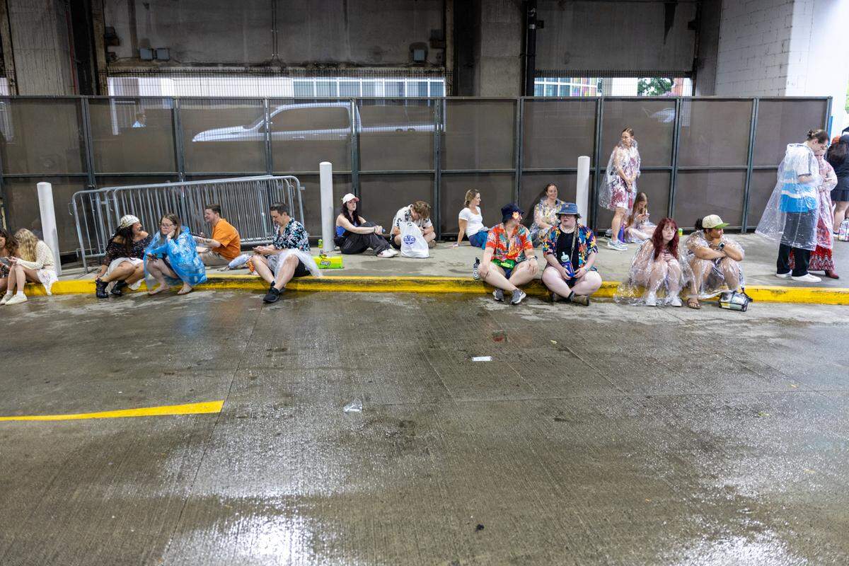 Fans shelter from lightning in a parking deck during Lovin’ Life Music Fest.