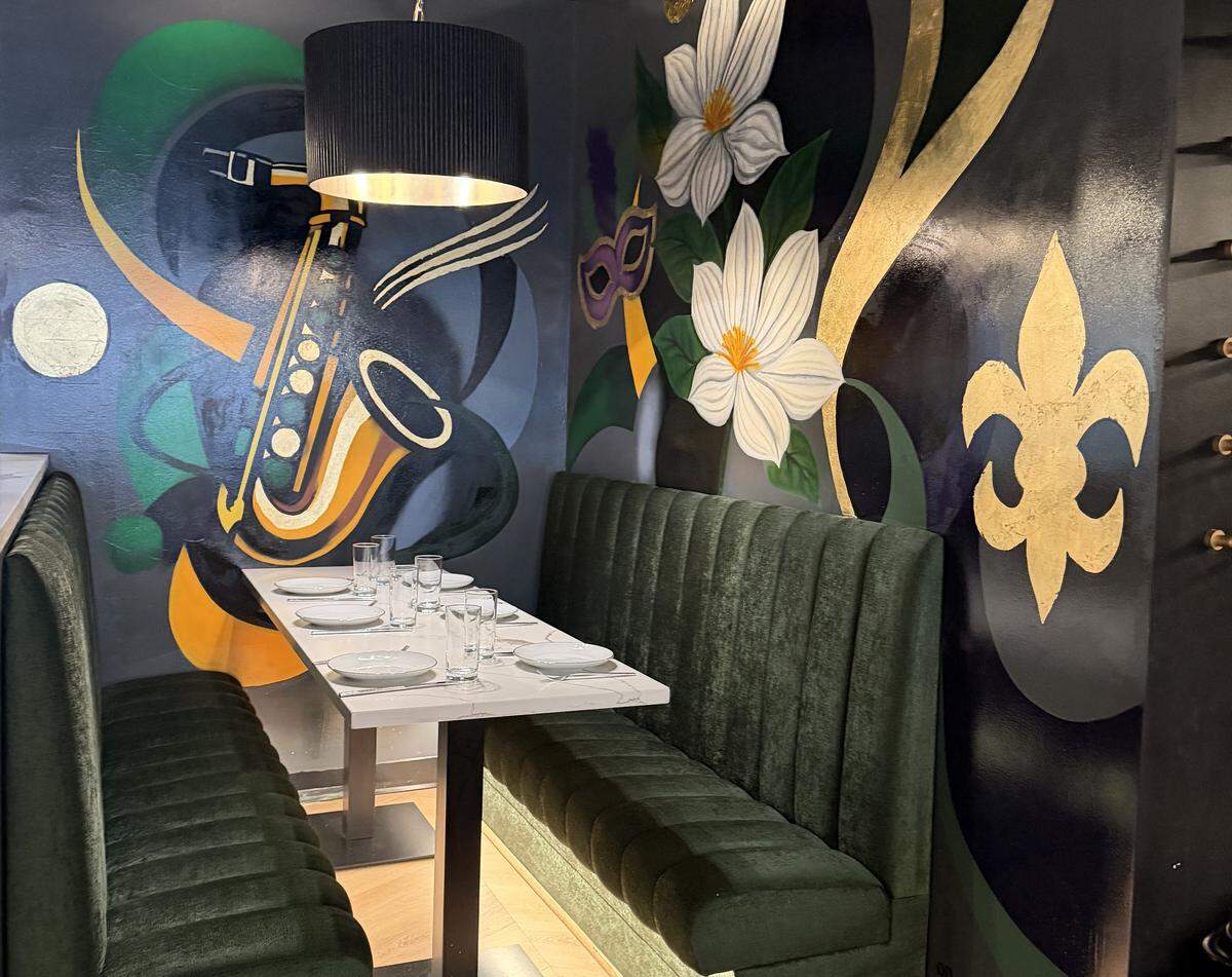One corner booth is elevated at Kristy’s Creole Kitchen in South End, featuring a mural done by Inigma Productions.