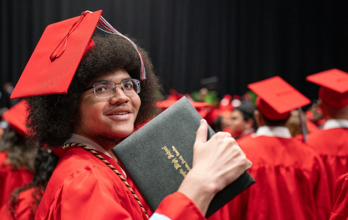 An Olympic High School graduate holds his recently awarded diploma during the graduation ceremony at the Bojangles Coliseum in Charlotte on Monday, June 10, 2024.