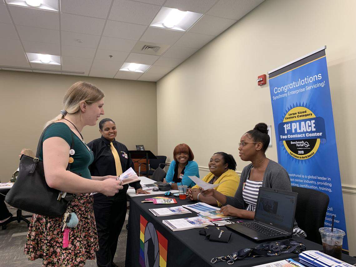 Blair Burns, left, speaks with representatives from Synchrony Financial at the trans job fair hosted by Charlotte Pride. Burns said that she has felt supported as a trans woman at her two current jobs, at Myers Park Country Club and at a fast-food restaurant, but wants to start looking for a full-time job with more room for career advancement.