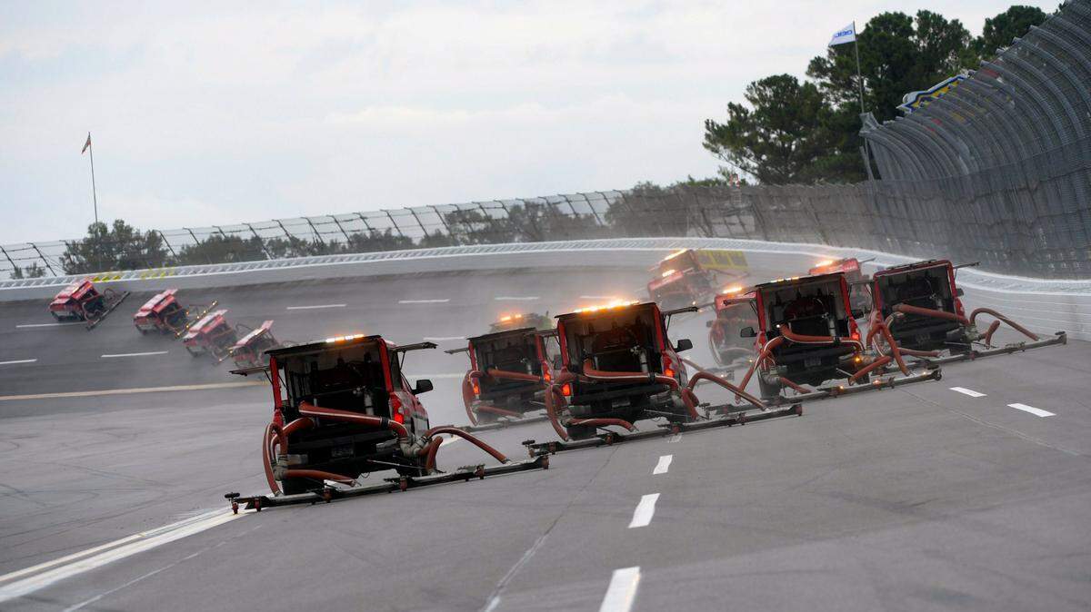 Trucks deploy to dry the track at Talladega Superspeedway before a NASCAR Cup series auto race Sunday, Oct. 3, 2021, in Talladega, Ala. (AP Photo/John Amis)