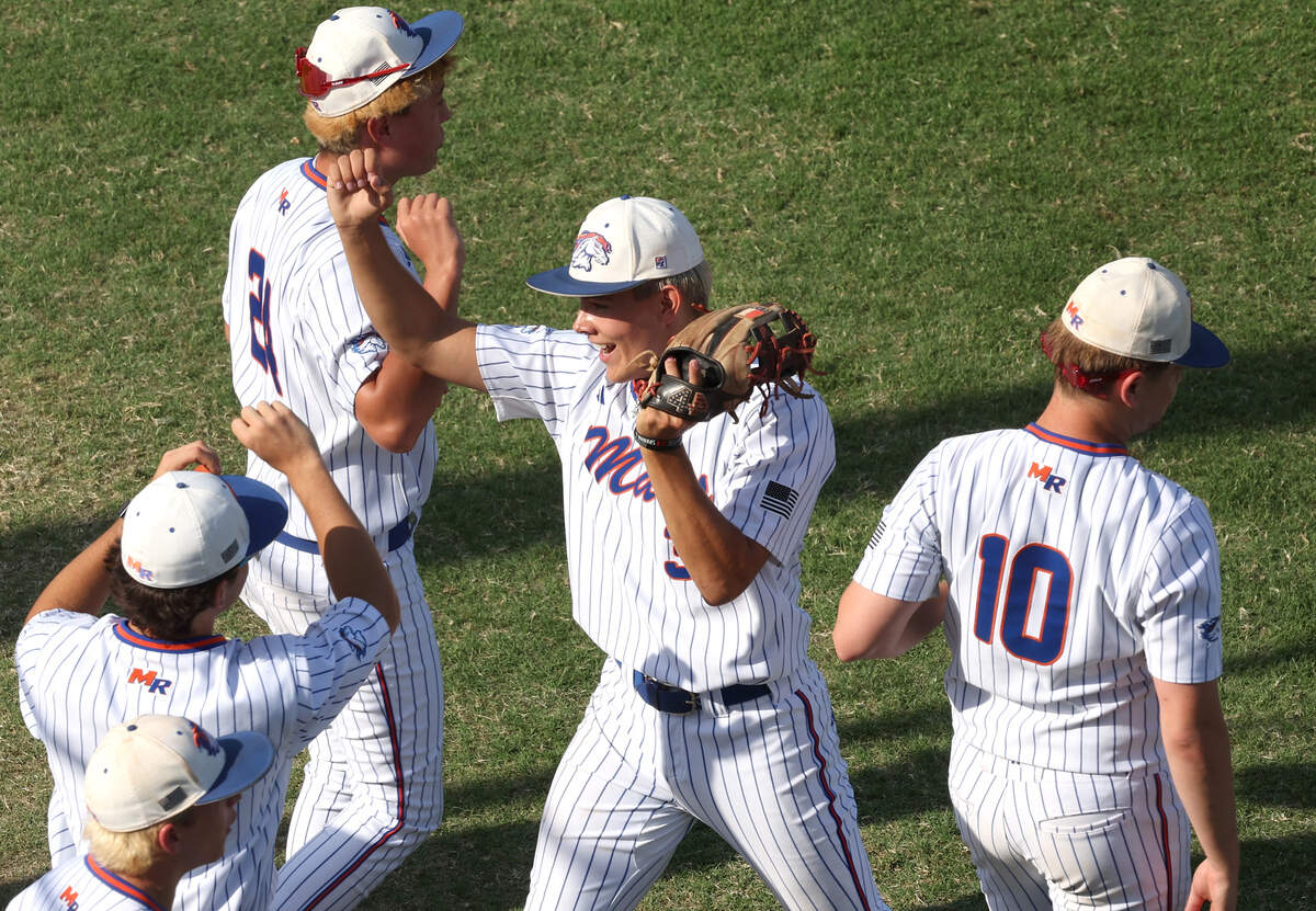 Marvin Ridge Mavericks starting pitcher Colin Slep, center, is congratulated by his teammates following a quick inning against the Holly Springs Hawks during Game 1 of the NCHSAA 7A Baseball Championship at Burlington Athletic Stadium on Friday, May 29, 2026, in Burlington, North Carolina. Holly Springs defeated Marvin Ridge 3-1.
