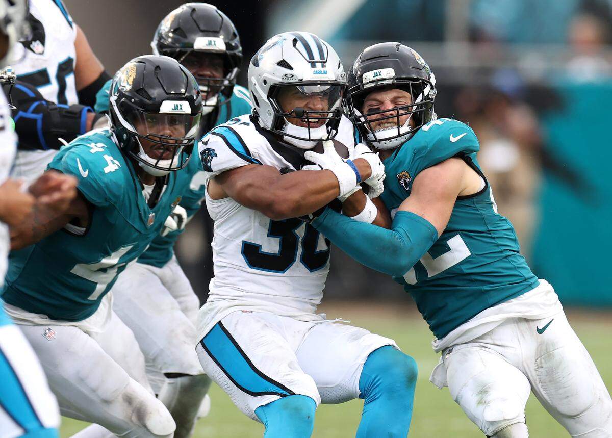 Carolina Panthers running back Chuba Hubbard, center, is tackled by Jacksonville Jaguars safety Andrew Wingard, right and his teammates during action on Sunday, September 7, 2025 at Everbank Stadium in Jacksonville, Florida. The Jaguars defeated the Panthers 26-10.