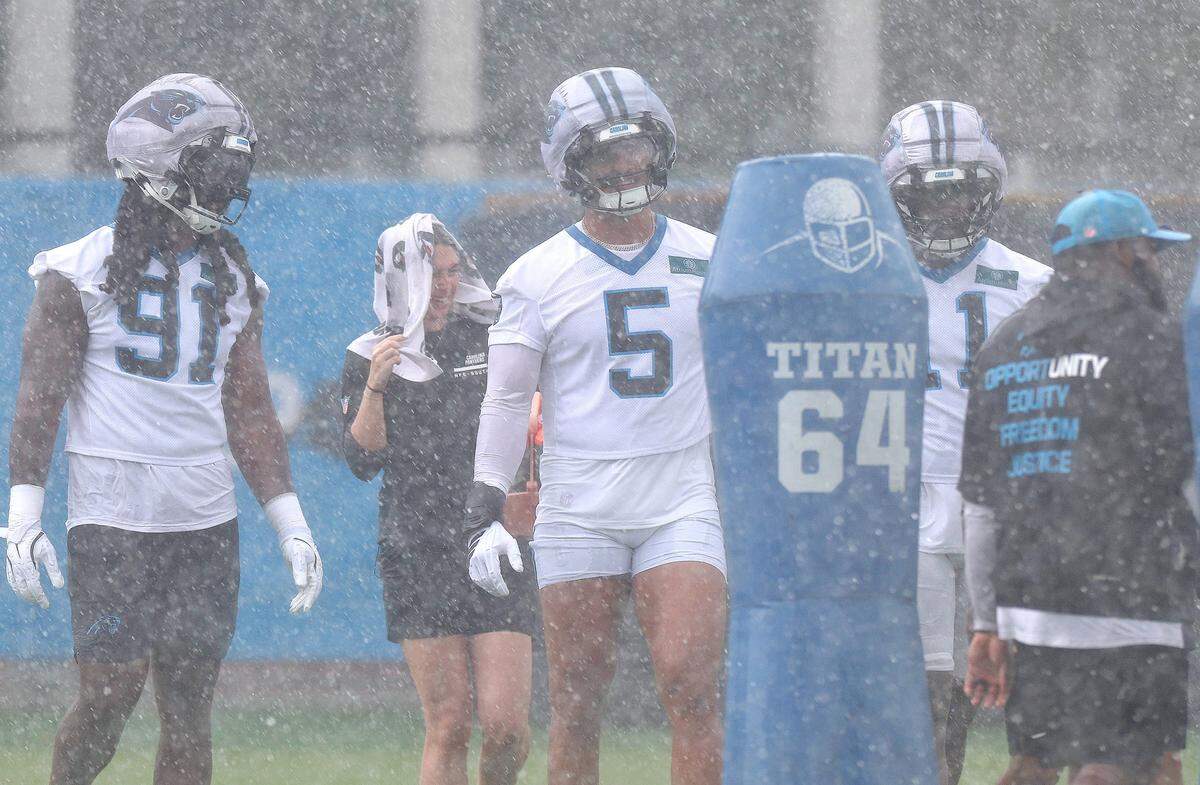Carolina Panthers linebacker Jean Phillips, center, waits to begin a series of plays during a downpour at the team's first open workout on Tuesday, May 26, 2026.