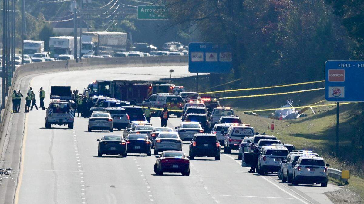 The remains of a helicopter sit to the right side of I-77 South past the Tyvola Road exit on Tuesday, November 22, 2022. Two people were confirmed dead in the crash, which involved a WBTV helicopter.
