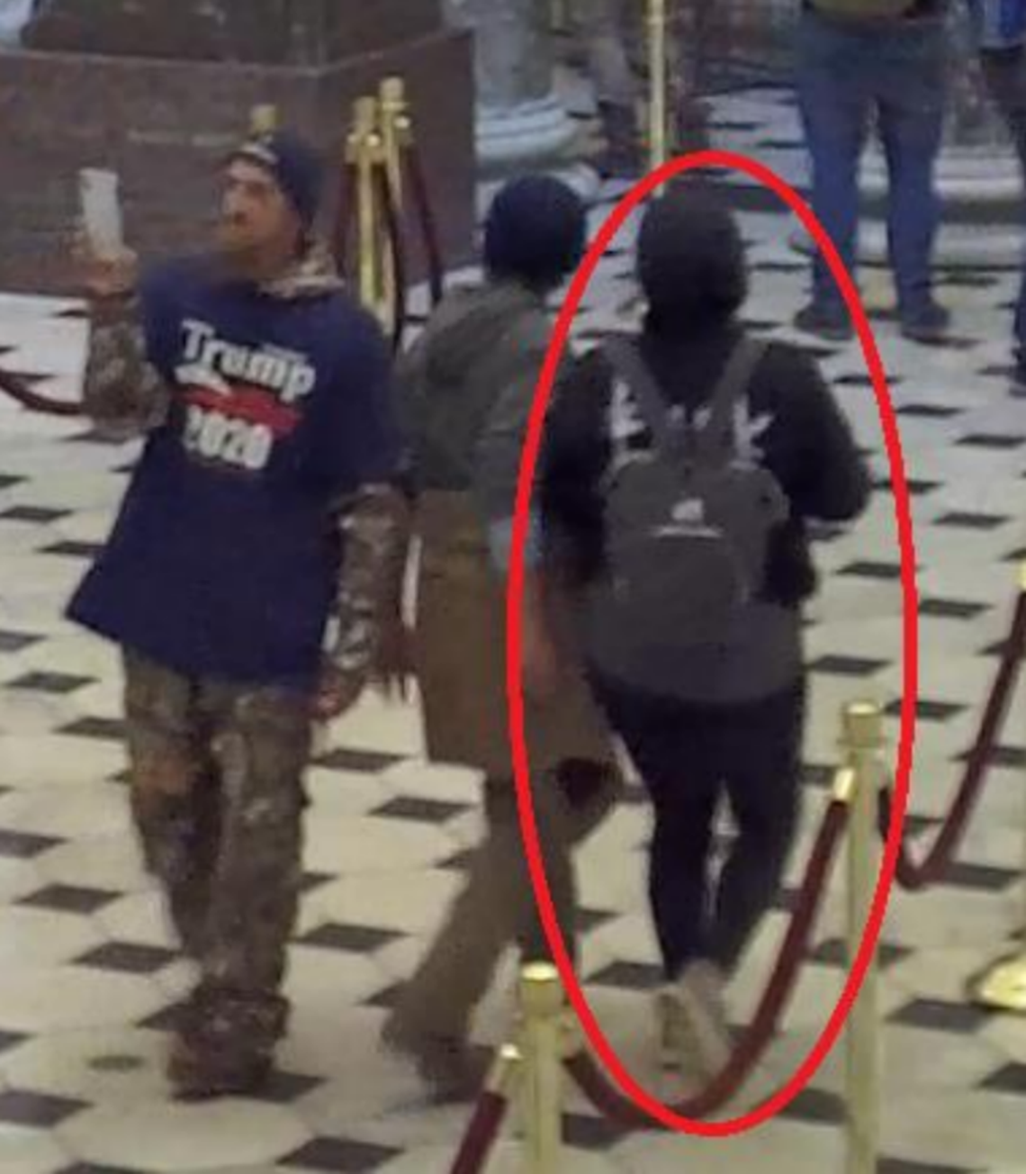 In this surveillance image, Chris Spencer records inside the Statuary Hall Connector at the U.S. Capitol as wife Virginia, right, and their son walk with others inside the U.S. Capitol on Jan. 6, 2021.