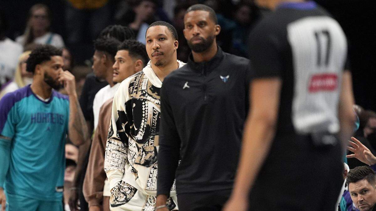 Charlotte Hornets forward Grant Williams (2) and head coach Charles Lee watch the offense during the second half against the Sacramento Kings at Spectrum Center..