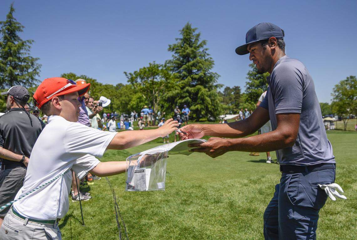 Tony Finau signs an autograph for Nolan Bates at the Pro-am for the Wells Fargo Championship at Quail Hollow Golf Course on May 2, 2018. (photo by Khadejeh Nikouyeh)