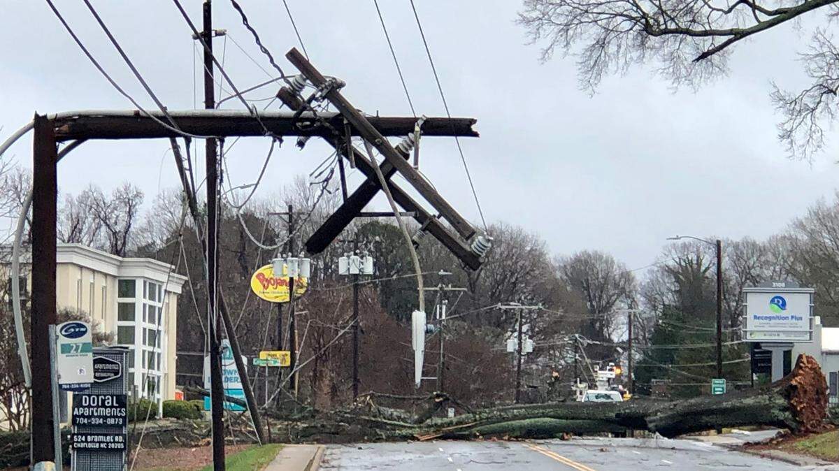 A broken telephone line stands along Monroe Road near Puhlman Street in Charlotte, NC on Sunday morning. A heavy rain with severe wind passed through the area knocking out power. A downed tree covers the four lanes of Monroe Road as a result of the storm.