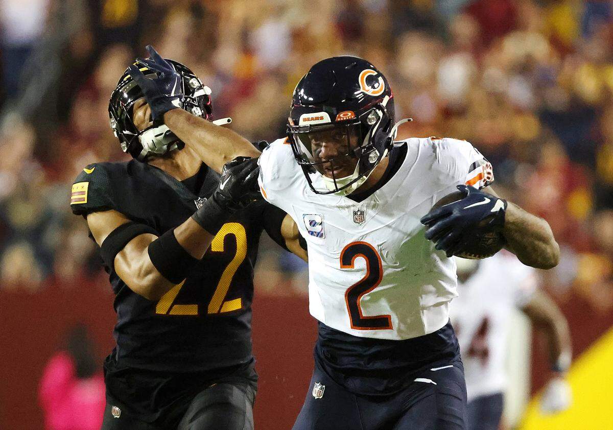Chicago Bears wide receiver DJ Moore (2) stiff-arms Washington Commanders safety Darrick Forrest (22) to pick up extra yardage after a first-quarter pass reception at FedEx Field on Thursday, Oct. 5, 2023, in Landover, Maryland. (Stacey Wescott/Chicago Tribune/TNS)