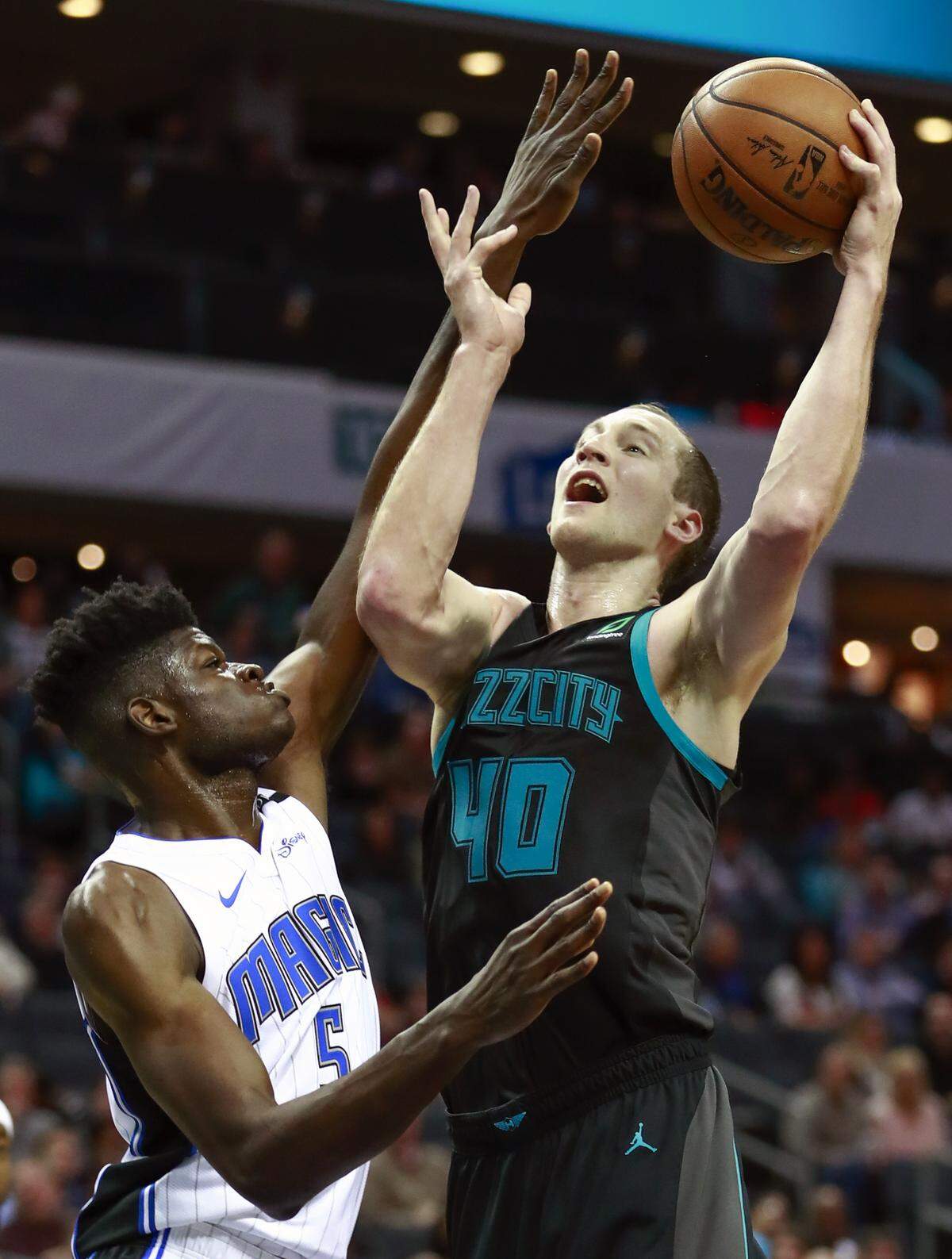 Charlotte Hornets center Cody Zeller (40) goes up a basket while being covered by Orlando Magic center Mo Bamba (5) in the first half of an NBA basketball game Monday, Dec. 31, 2018, in Charlotte, N.C. (AP Photo/Jason E. Miczek)