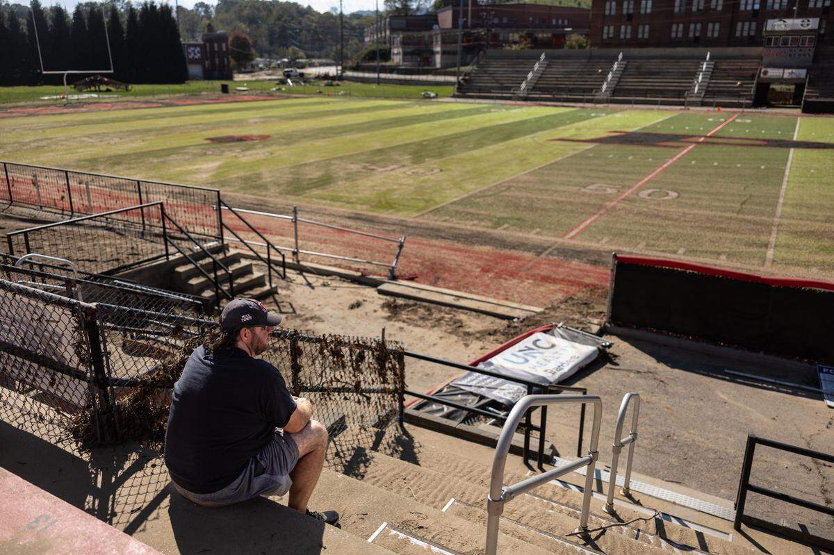 Jody Mathis sits in the stands of the football stadium that was flooded during Hurricane Helene at Pisgah High School in Canton, N.C., on Tuesday, October 8, 2024.
