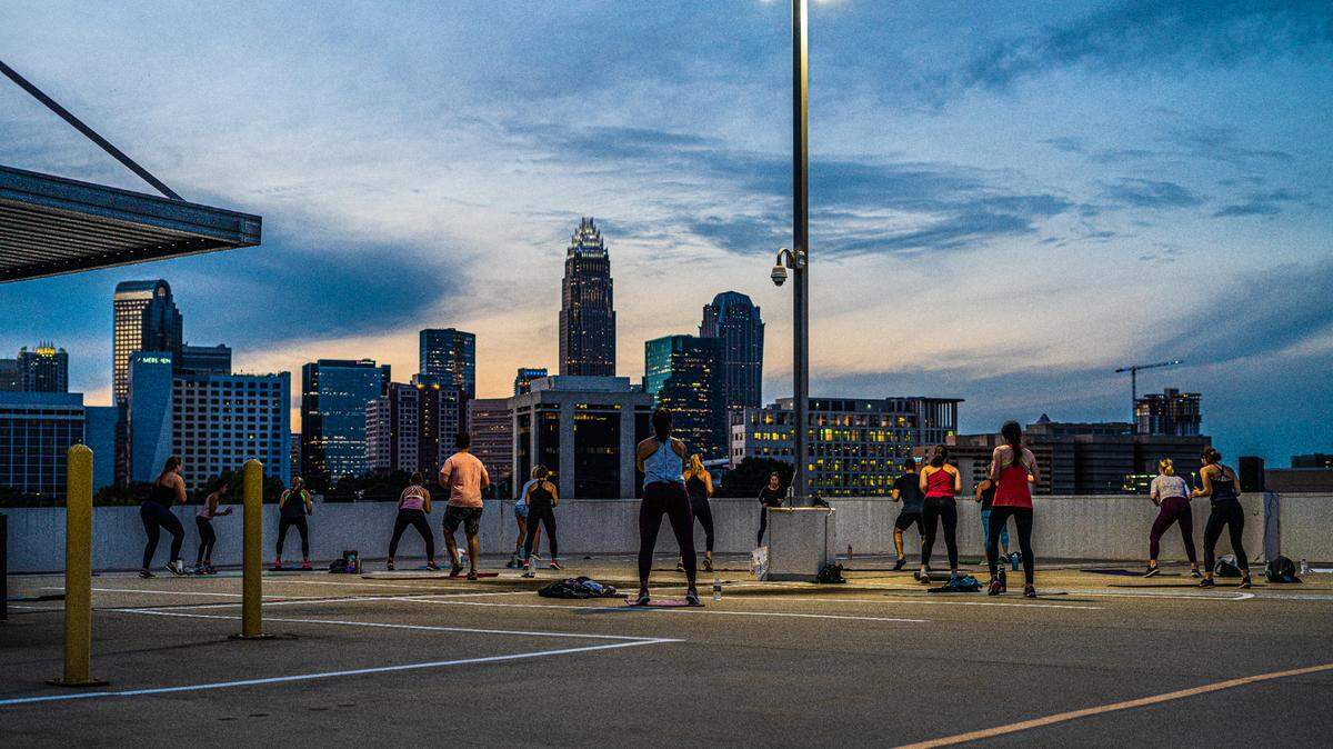Sweatnet’s outdoor workouts are full of variety, including bootcamp, barre, HIIT and more. Shown here is a sunset rooftop yoga class.