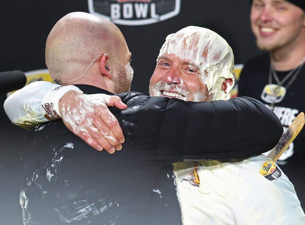 Minnesota Golden Gophers head coach P.J. Fleck, right, hugs an ESPN commentator after he was covered in Duke’s Mayonnaise following the team’s victory over Virginia Tech in the Duke’s Mayo Bowl at Bank of America Stadium in Charlotte, NC on Friday, January 3, 2025. Minnesota defeated Virginia Tech 24-10.