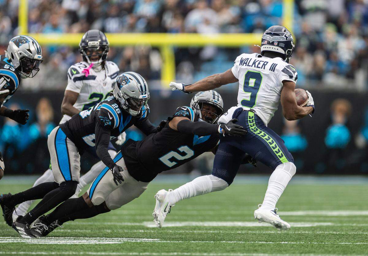 Seattle Seahawks running back Kenneth Walker III, right, is tackled by Carolina Panthers cornerback Mike Jackson at Bank of America Stadium on Dec. 28, 2025.