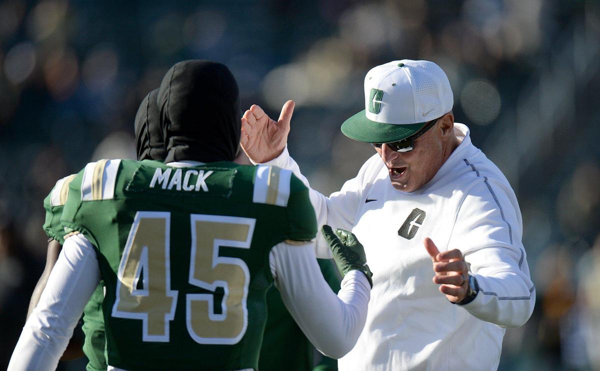 Charlotte 49ers interim coach Tim Brewster greets senior brothers Jaavan and Jairus Mack on Saturday during the game against UAB.