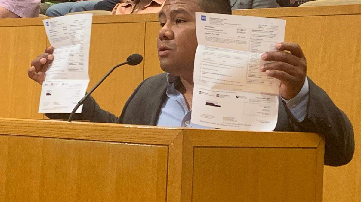 Fruit vendor Jorge Castaneda holds up past due credit card bills at a recent Charlotte City Council meeting that he claims are due to the Central Flea Market closing down. Open air market vendors could have “new home” in southeast Charlotte after months of being displaced from the Eastland Mall site they were booted out of in February.