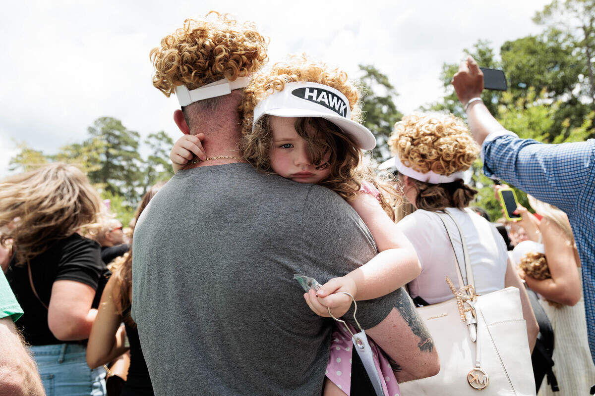 Sporting “The Hawk” visors and hair, Anne Stewart (4) hangs onto her dad, Billy Stewart, outside the crowd of fans seeking interaction with Will Ferrell as Lonnie Hawkins at the World Golf Hall of Fame on Thursday, June 18, 2026 in Pinehurst, NC.