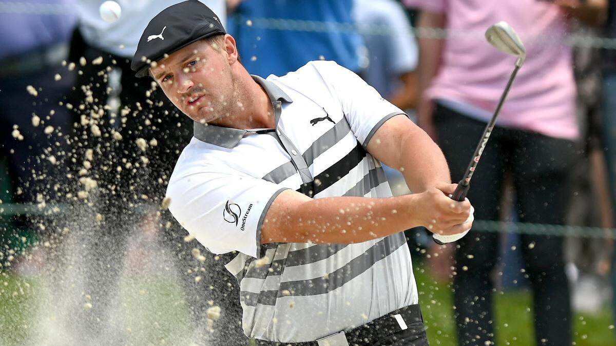 Golfer Bryson DeChambeau hits from a sand trap along the 18th green during third round action of the Wells Fargo Championship at Quail Hollow Club in Charlotte, NC on Saturday, May 8, 2021.