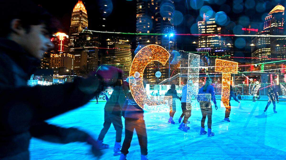The Charlotte skyline provides the backdrop as patrons skate on the ice rink at Truist Field on Wednesday. The Charlotte Knights welcomed families and fans to Truist Field for the fourth season of Light the Knights Festival filling the field with thousands of holiday lights, trees and displays to create a winter wonderland. Adding to the excitement for families is the regulation size ice rink and a 10-lane, 150-foot snow tubing hill.