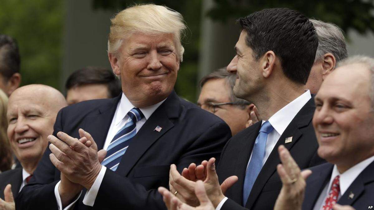 President Donald Trump and then House Speaker Paul Ryan share a smile last May at a Rose Garden celebration of the American Health Care Act.