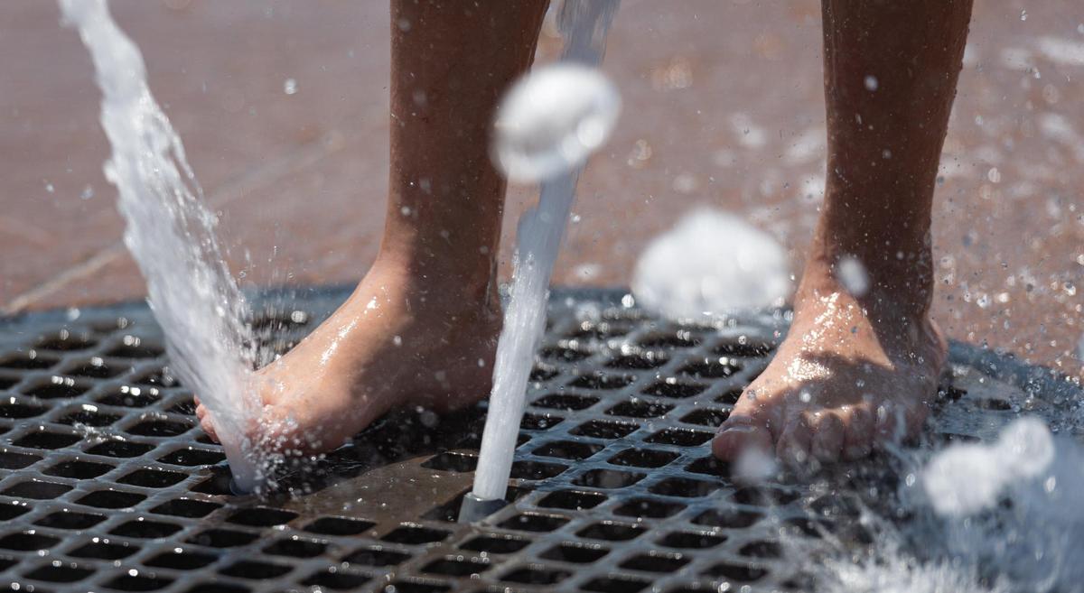 Jennica Perez, 7, cools offer her feet at First Ward Park sprayground in uptown Charlotte, North Carolina, on Monday, June 13, 2022. Temperatures could reach 100 degrees on Tuesday.