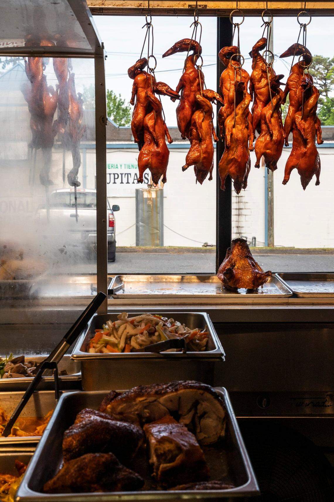 Whole Vietnamese roasted ducks hang on display in the window of Van Loi Chinese Barbecue in Charlotte.