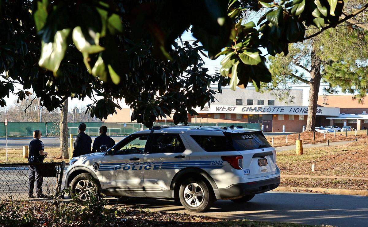 Charlotte-Mecklenburg police officers stand watch outside of West Charlotte High School on Monday, December 13, 2021. Officials say a fight over a book bag led to gunfire on the campus.