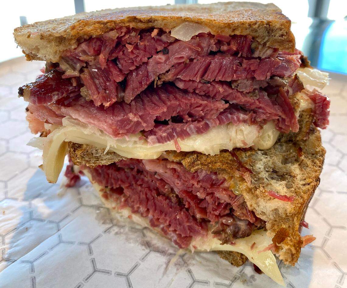 Meshugganah’s popular pastrami and corned beef sandwiches are finding a home at Joan’s Bakery.