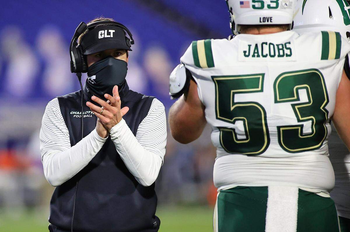 Will Healy (left) has had to tell his Charlotte 49ers football team on eight different occasions this year that an upcoming game was canceled or postponed due to COVID-19.
