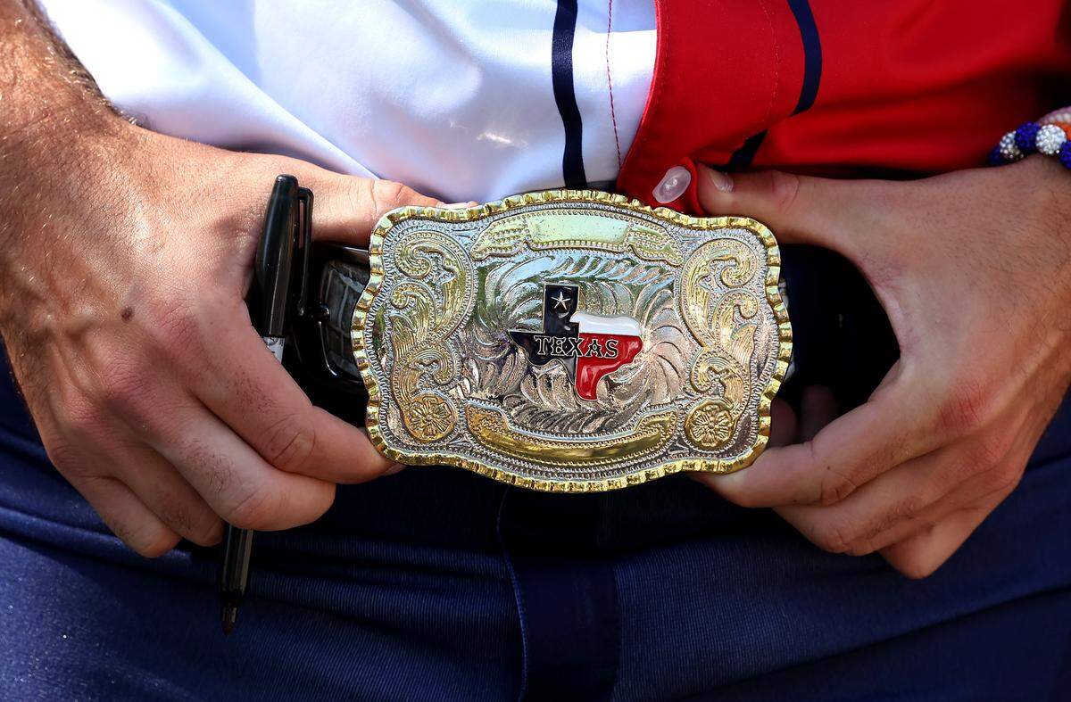 A member of the Texas Tailgaters wears a brilliant Texas belt buckle with his uniform as he meets and greets fans outside Truist Field in Charlotte, NC on Thursday, June 4, 2026. Banana Ball featured a game between the Texas Tailgaters and Firefighters.
