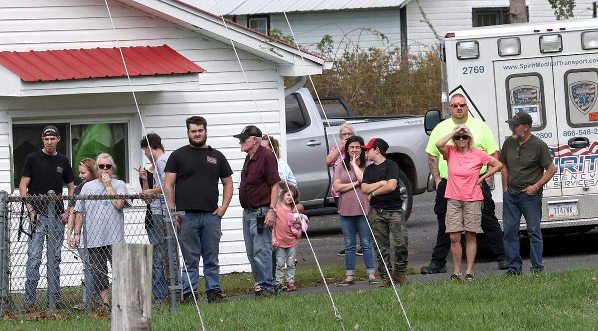 Citizens of the Buladean, N.C., community stand near the landing zone for a Chinook helicopter flown by Bravo Company 1-171 on Thursday, Oct. 3, 2024. The company delivered bottled water and ready to eat meals to the community in Western North Carolina suffering the effects of Hurricane Helene.