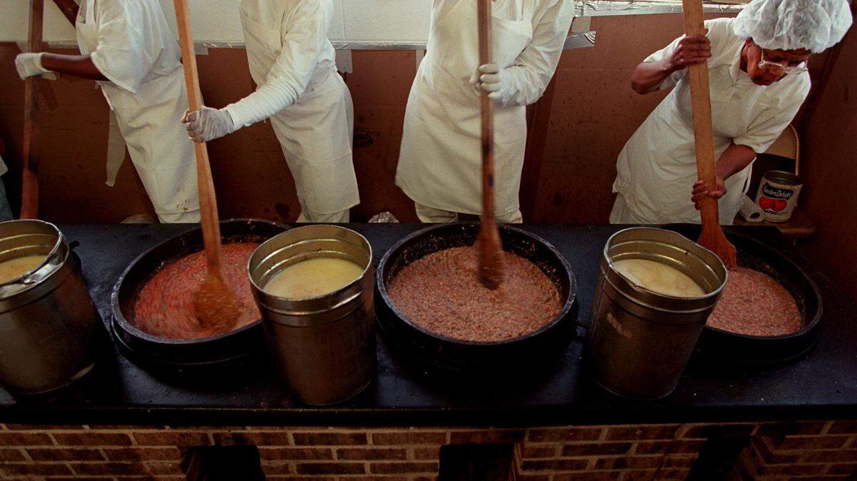 Lucile Moungle (right), 68, stirs a 5-gallon pot of Brunswick stew to keep the stew from burning, as she has the past 23 years for the Mallard Creek Barbecue on Thursday, Oct. 24, 1997. The festival also serves a heaping plate of politics. 