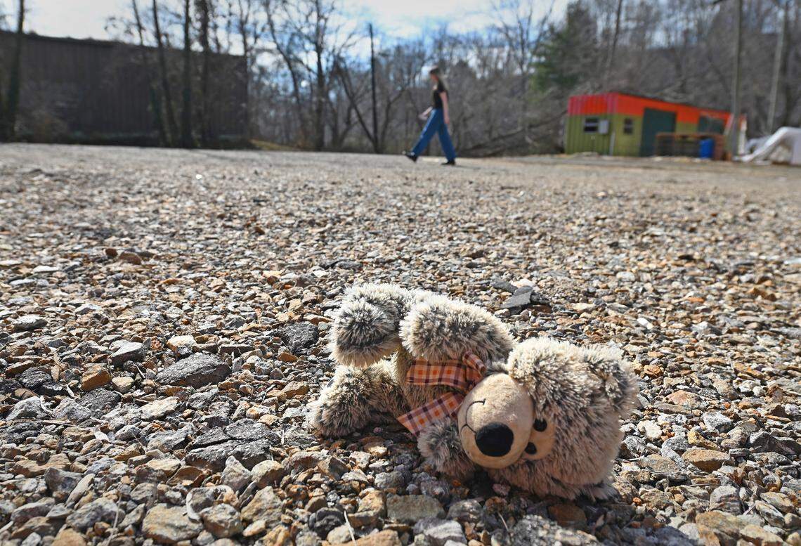 A teddy bear lays on the formerly paved parking lot of Zen Tubing in Asheville, NC on February 5, 2025. The nearby French Broad River rose above its banks during Hurricane Helene and flooded local businesses. Zen Tubing will be operating from a second site this season.