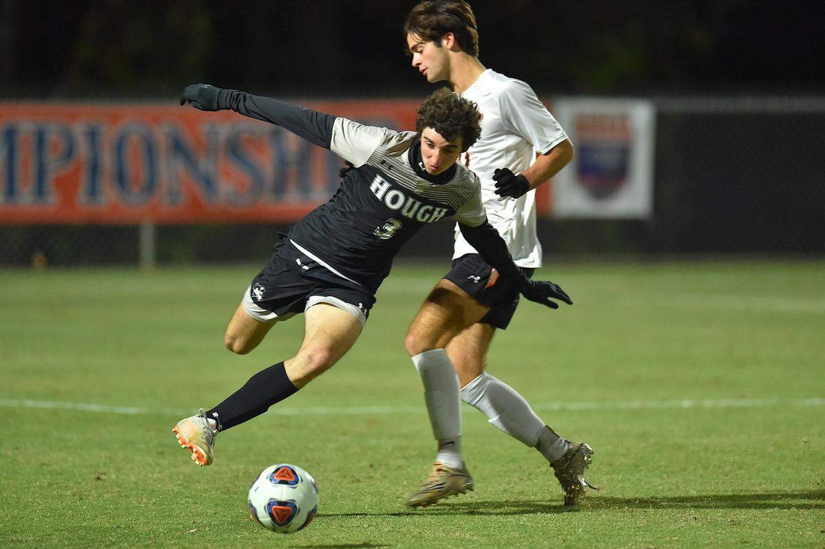 HOugh’s Cole Skovira (3) defends the ball against New Hanover’s John Franck (11) during the first half. The New Hanover Wildcats and the Hough Huskies met in the NCHSAA 4A Boys Soccer Championships in Cary, N.C. on November 20, 2021.