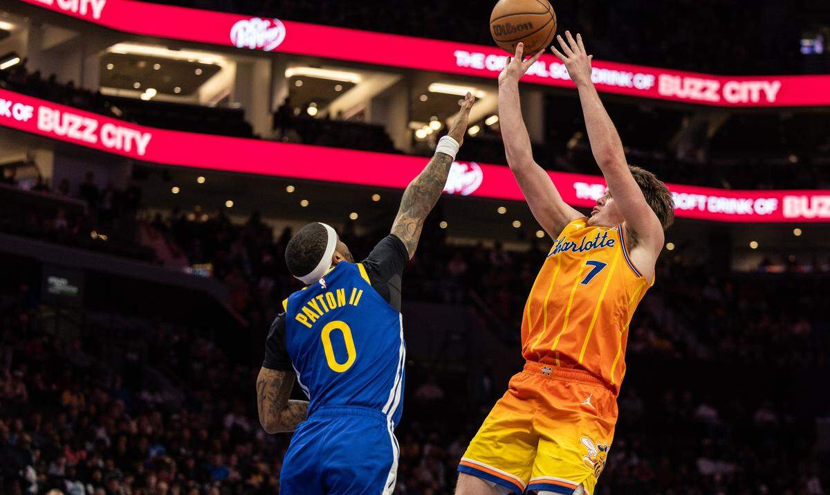 Charlotte Hornets guard Kon Knueppel, shoots past a block by Golden State Warriors guard Gary Payton II at the Spectrum Center in Charlotte, N.C., on Wednesday, December 31, 2025.