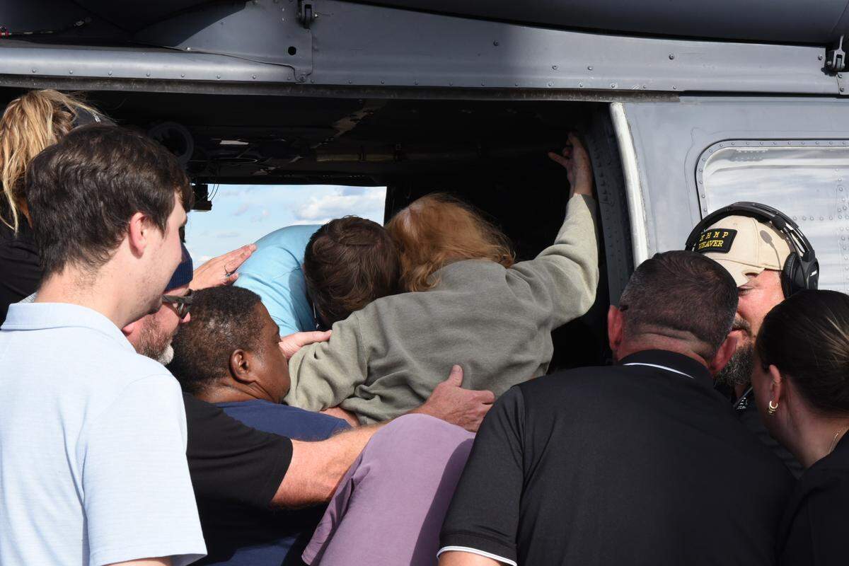 Staff with the company ALG Senior and volunteer nurses carry a nursing home resident from Burnsville, N.C., out of a rescue helicopter in Hickory on Tuesday, Oct. 1, 2024. The helicopters are flown by volunteer pilots.