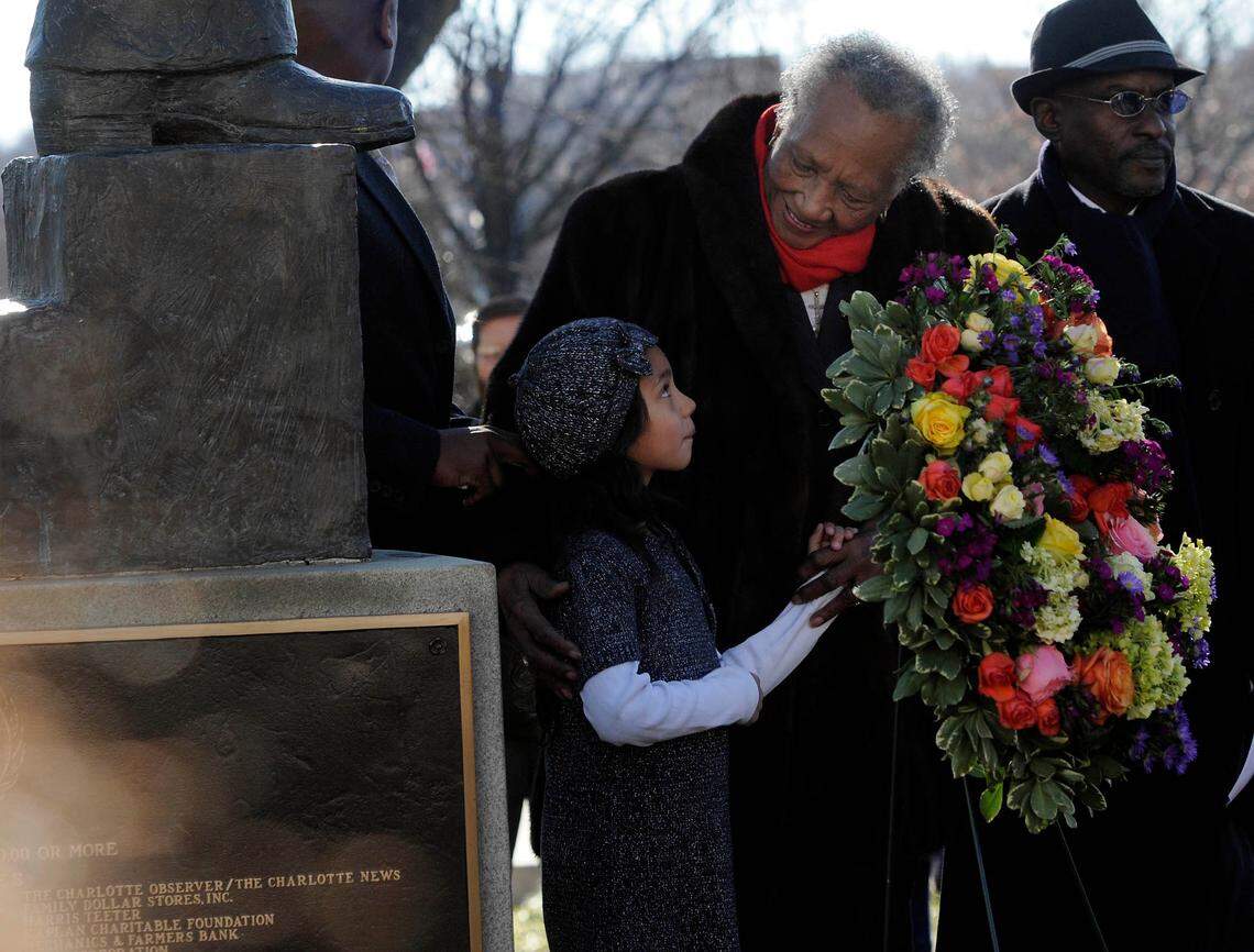 Hannah Hough, left, looks up at Sarah Stevenson after helping to place a wreath at the base of the Martin Luther King, Jr. statue during the annual Martin Luther King, Jr. Memorial at Marshall Park in uptown Charlotte on January 15, 2012.