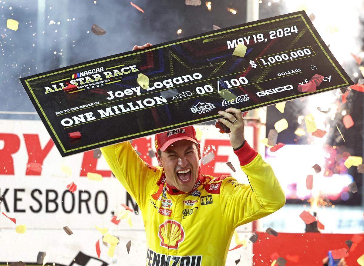 NASCAR Cup Series driver Joey Logano holds a $1 million check as he and his team celebrate winning the NASCAR All-Star race at North Wilkesboro Speedway in North Wilkesboro, NC on Sunday, May 19, 2024.