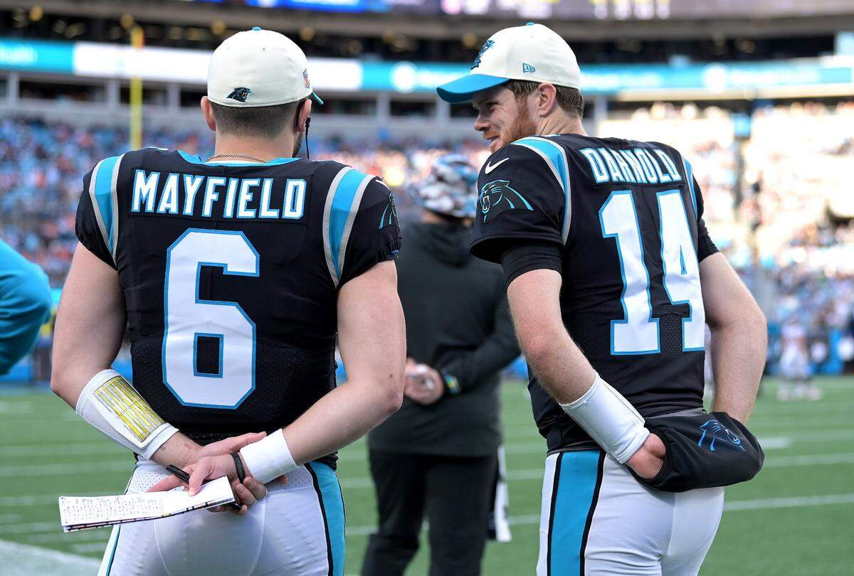 Carolina Panthers quarterbacks Baker Mayfield (left) and Sam Darnold talk during a 2022 game while they both played for the Panthers.